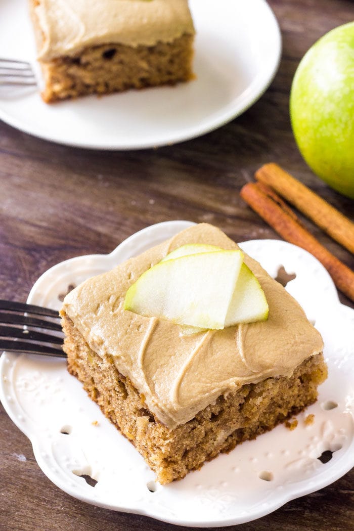 A slice of apple cake with caramel frosting topped with apple slices