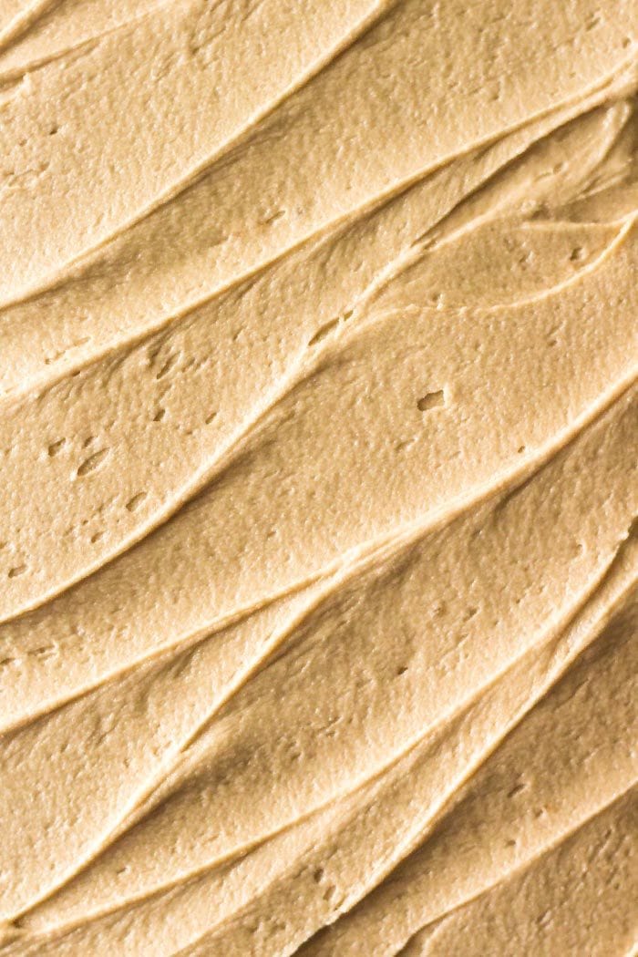 Overhead shot of fluffy caramel frosting on an apple spice cake