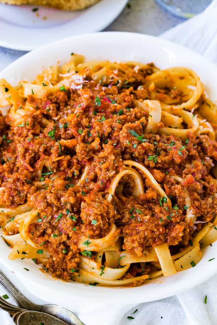 A white pasta dish full of fettuccini loaded with authentic Italian Bolognese sauce