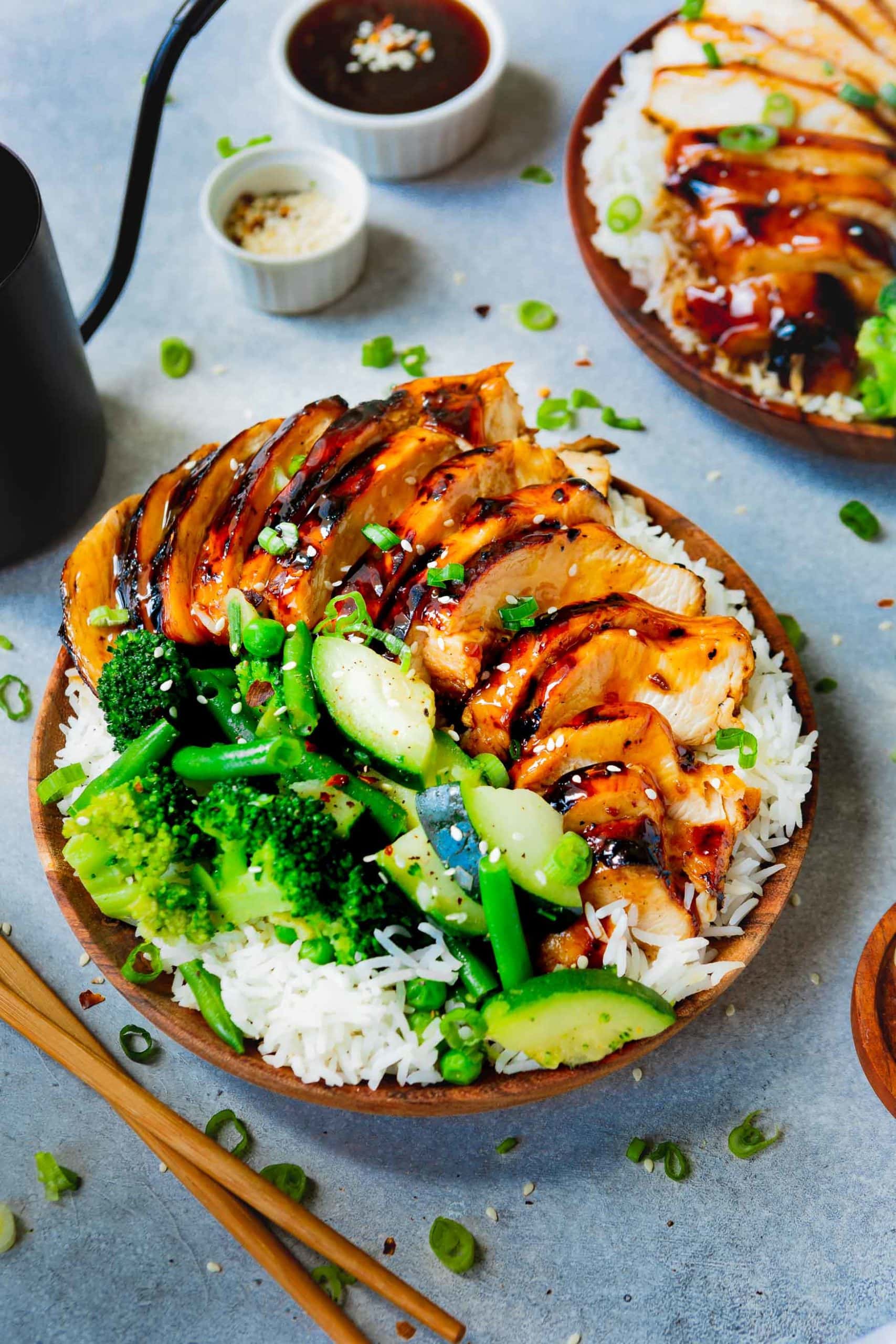 Easy Teriyaki Chicken a photo of a plate of rice covered with teriyaki chicken and steamed broccoli, green beans and zucchini.