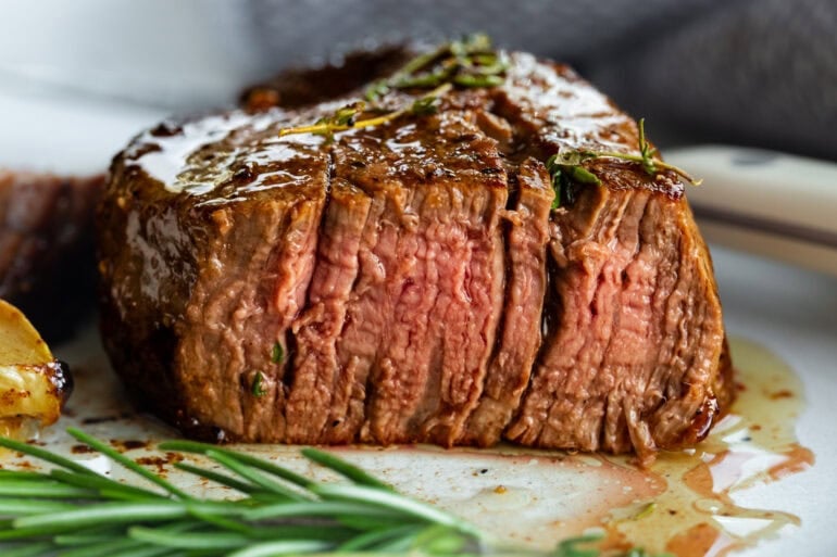 the cross-section of a cookies filet mignon with a pink center and beautiful sear on the outside