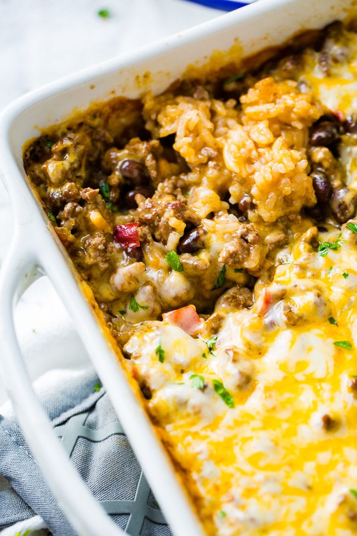 a white casserole dish with a Mexican cheesy ground beef and rice casserole
