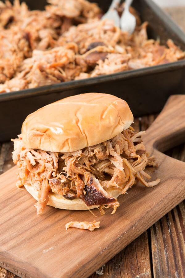 Want to make the best pulled pork from your own kitchen? This recipe for the world's best Carolina pulled pork all starts with a brine. best pulled pork sandwich on wooden serving board